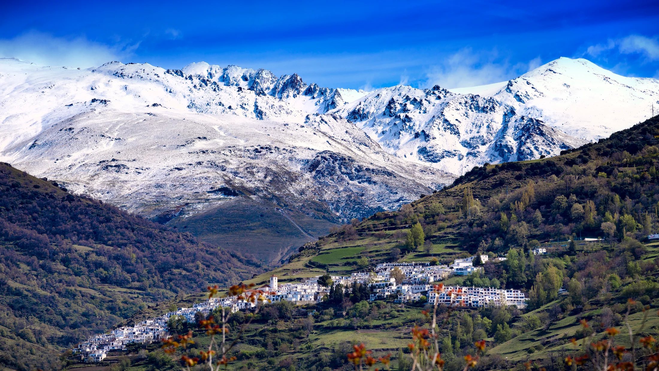 Capileira, en Las Alpujarras, con la pared sur de Sierra Nevada al fondo. Base habitual de llegada de las travesías.